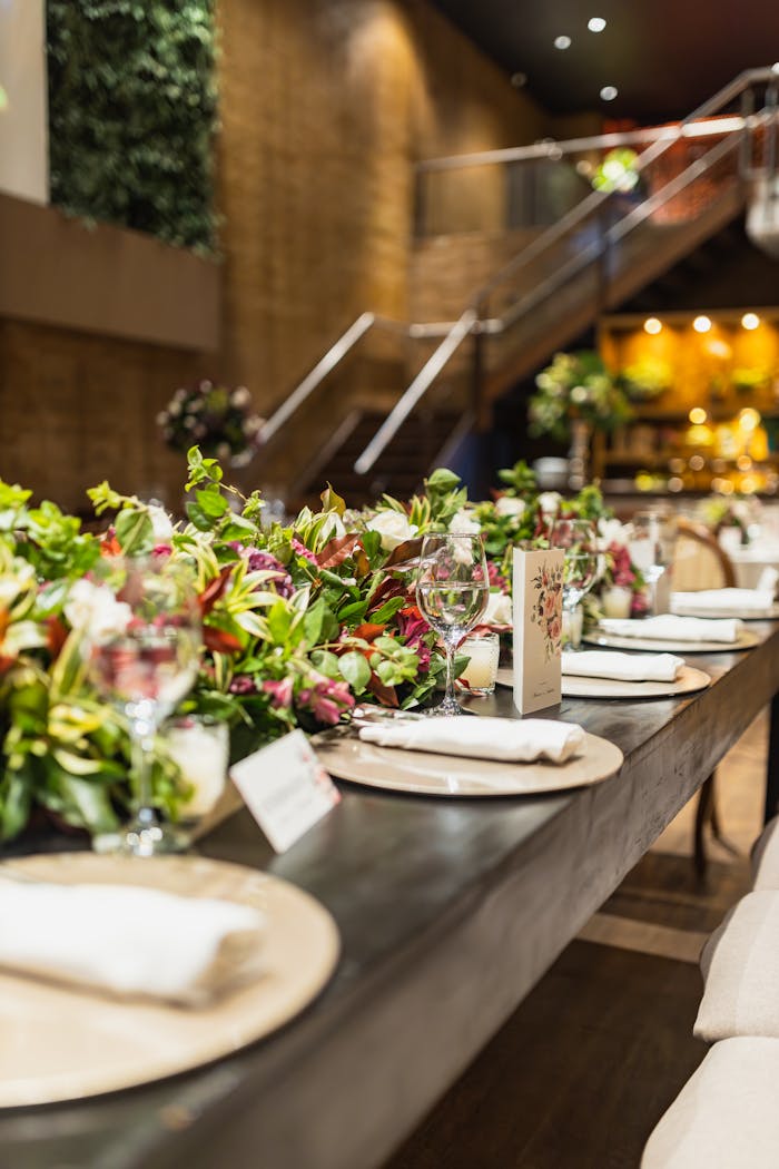 A beautifully arranged table with floral centerpieces at a wedding reception indoors.